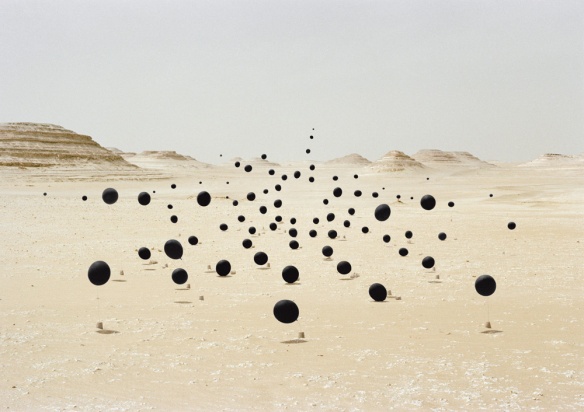 Surreal photo by Andrea Galvani of black balloons in desert landscape.