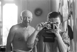 Pablo Picasso shirtless, taken in mirror.