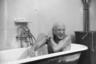 Pablo Picasso shirtless in bathtub.