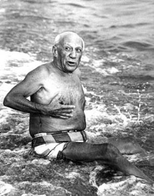 Pablo Picasso shirtless on the beach.