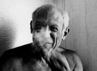 Pablo Picasso shirtless and smoking.