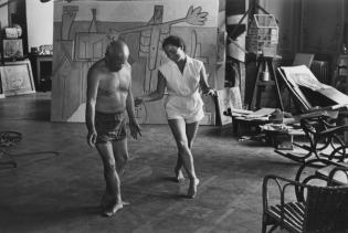 Pablo Picasso shirtless, dancing with woman.