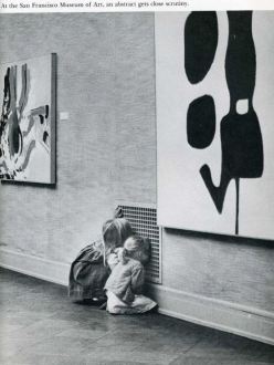Two little girls captivated by looking through a vent instead of the modern art on the museum walls.