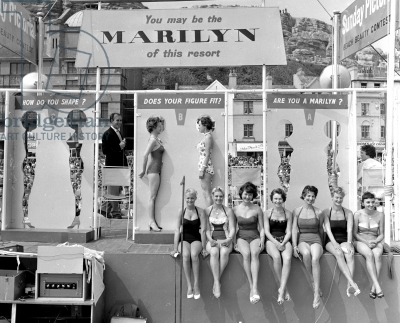 Contestants measure their bodies against cutouts of the star in a Marilyn Monroe look-a-like contest, 1958.
